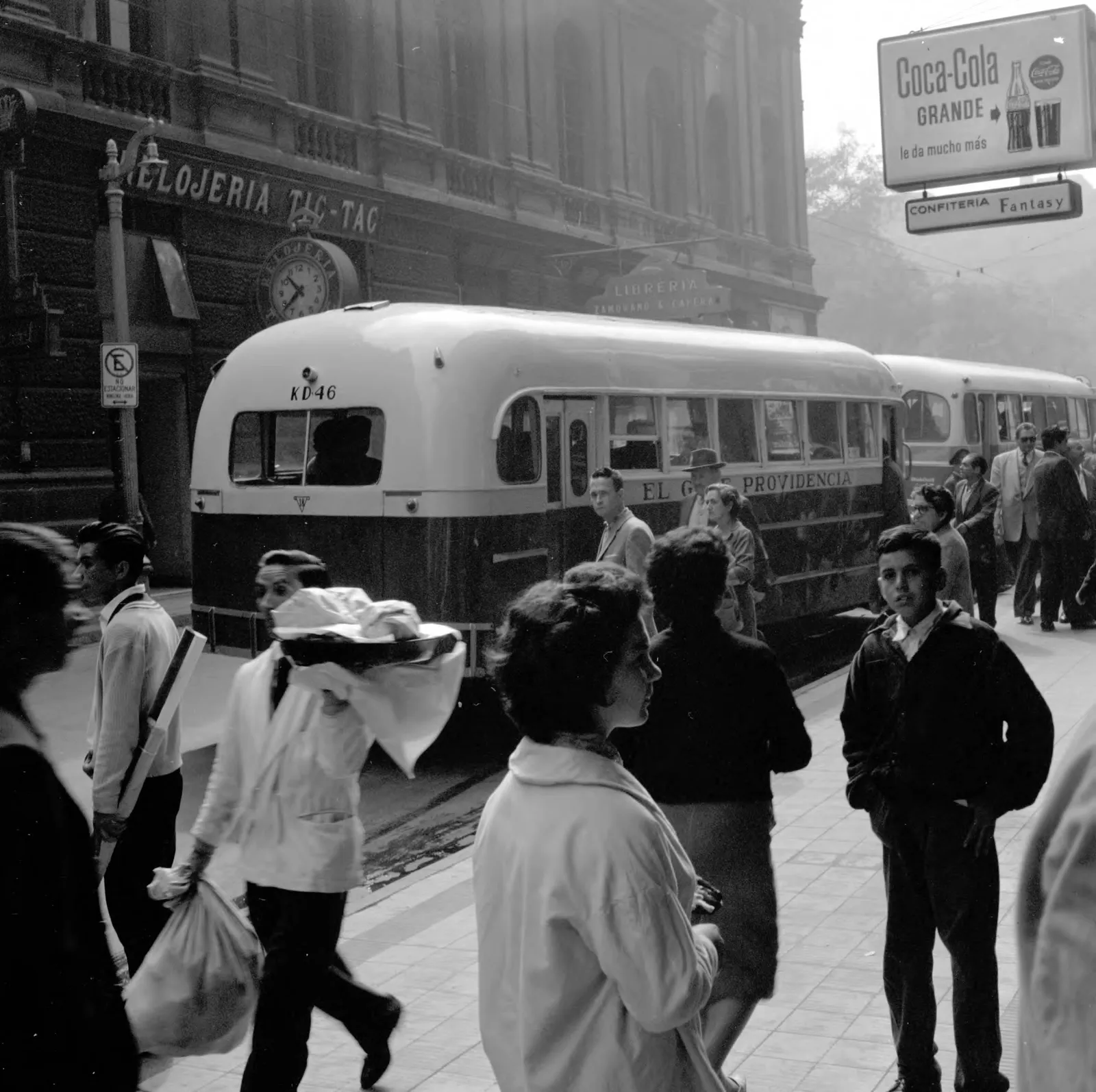 Peatones esperando en la parada de autobús en Santiago ca. 1960.