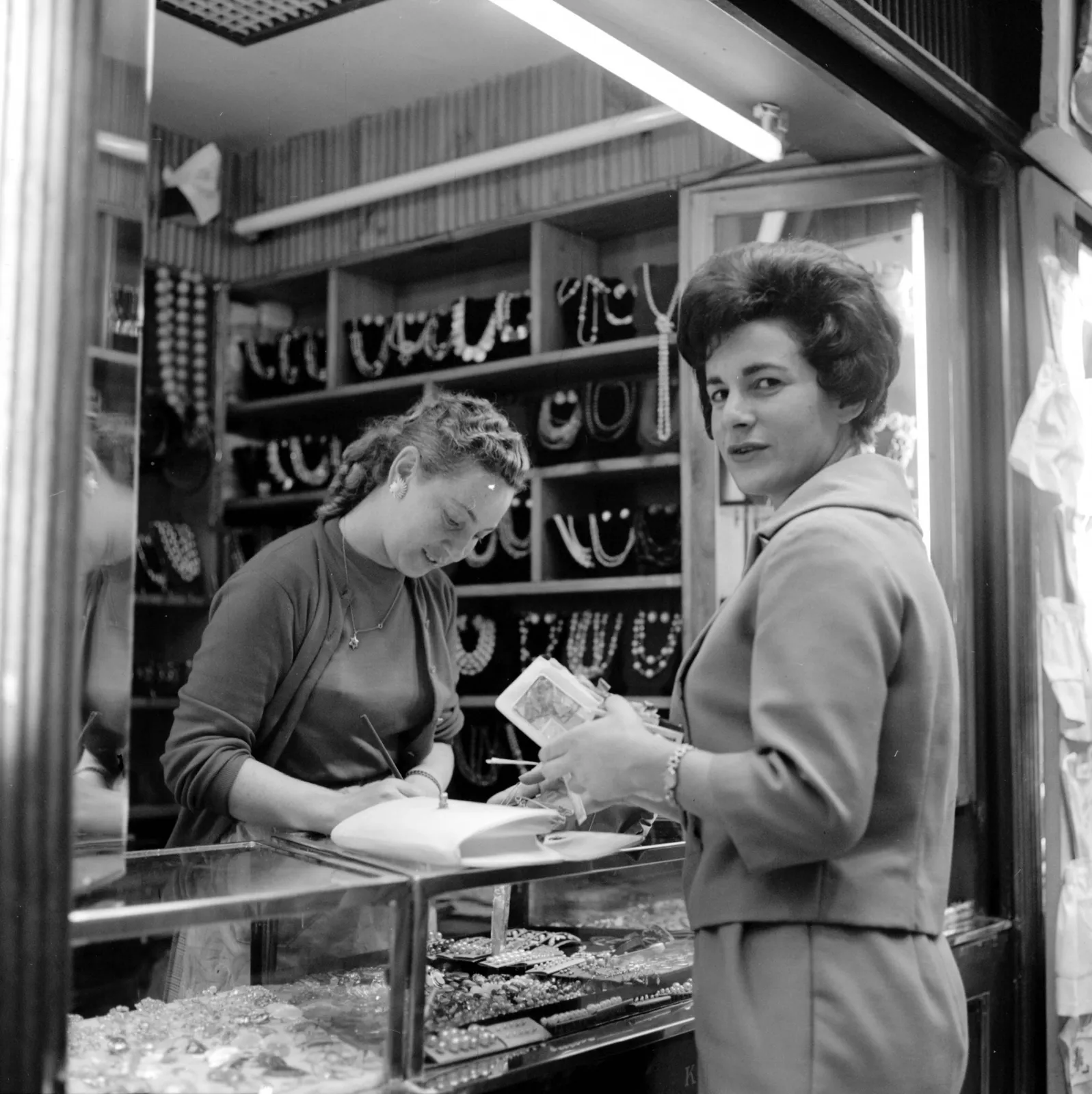 Mujer comprando joyas en tienda de Santiago ca. 1960.