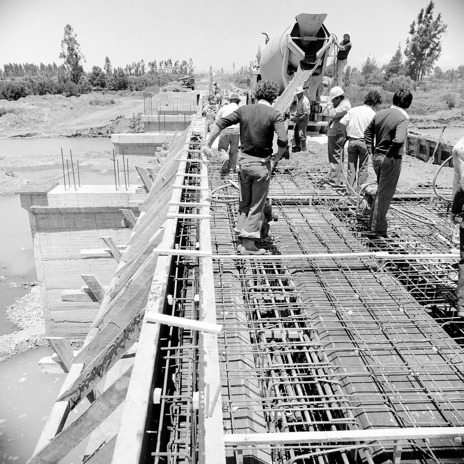 Obreros aplican pavimento sobre un puente