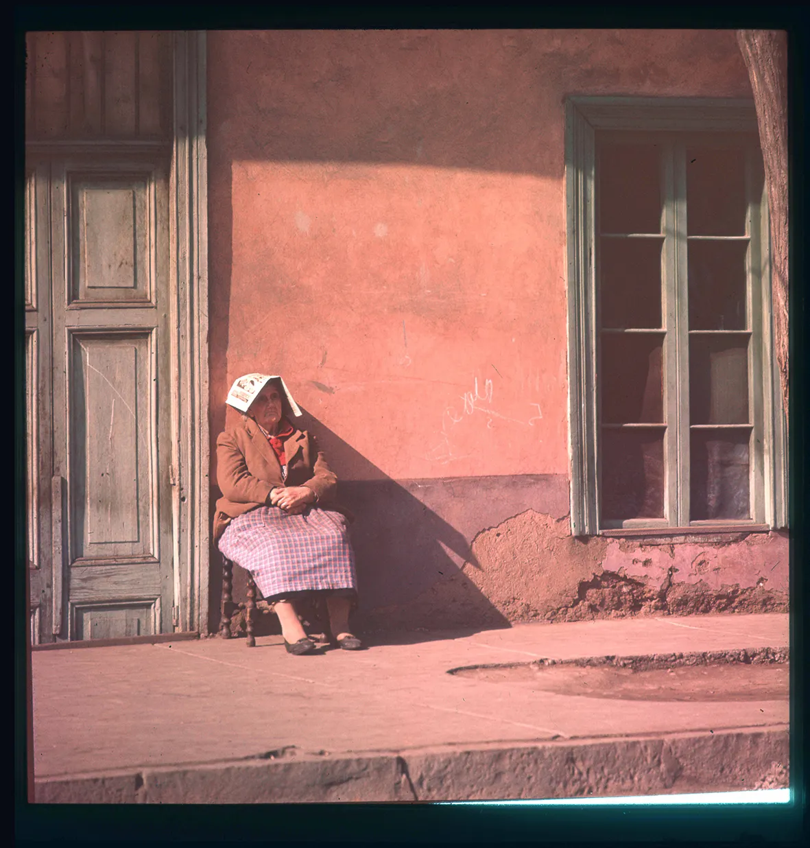 Mujer sentada afuera de una casa, Chile, 1950 - 1965