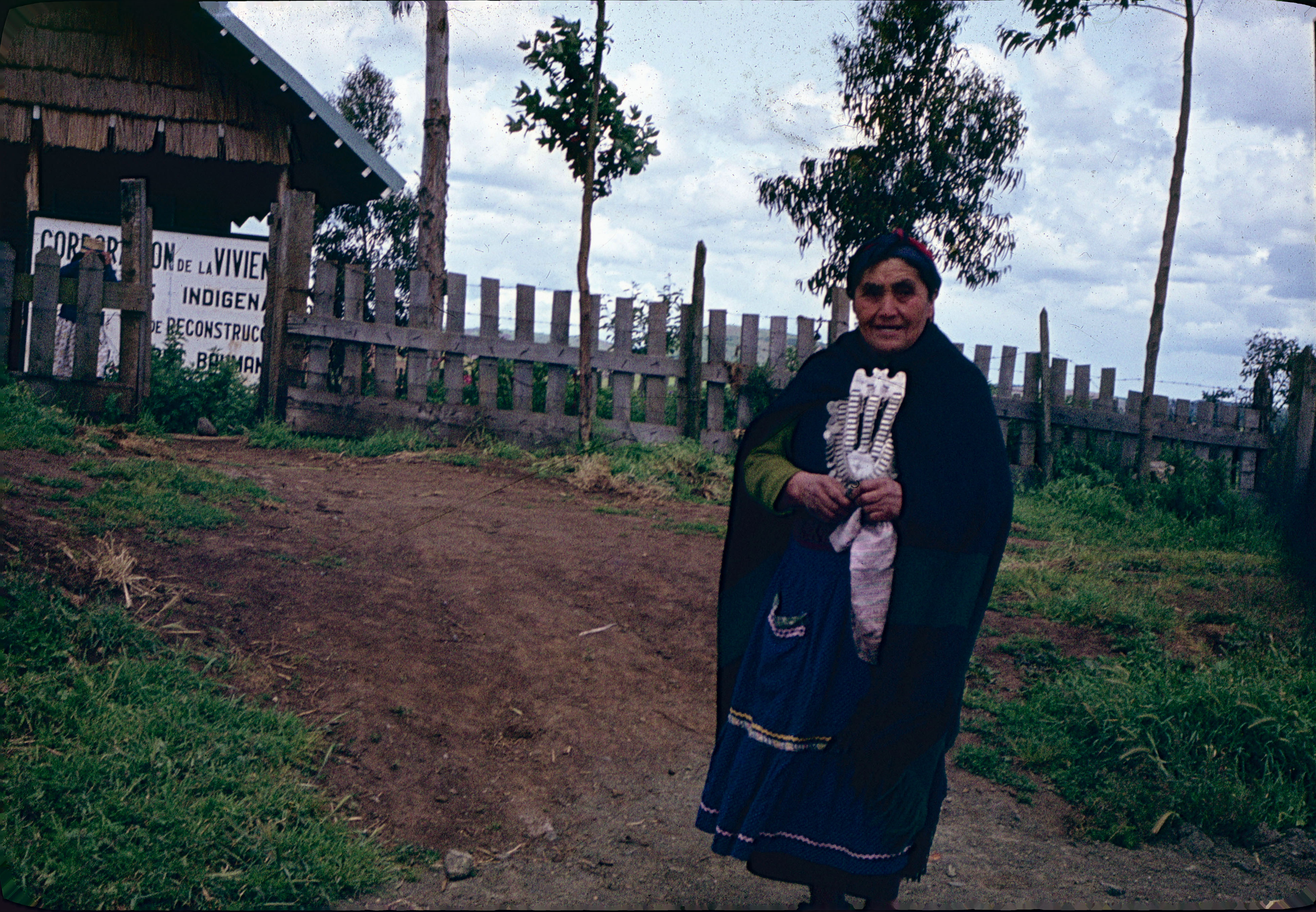 Mujer mapuche frente a letrero CORVI, ca. 1965