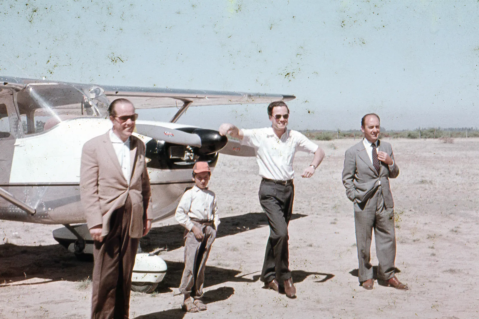 Personas frente a avioneta circa. 1965