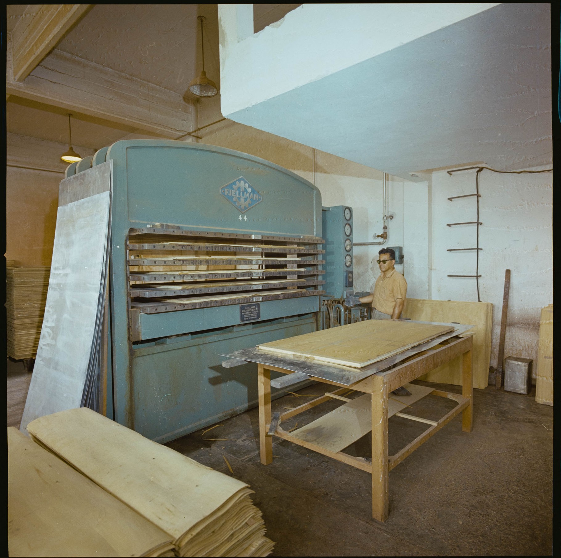Hombre frente a una máquina que procesa madera, 1964