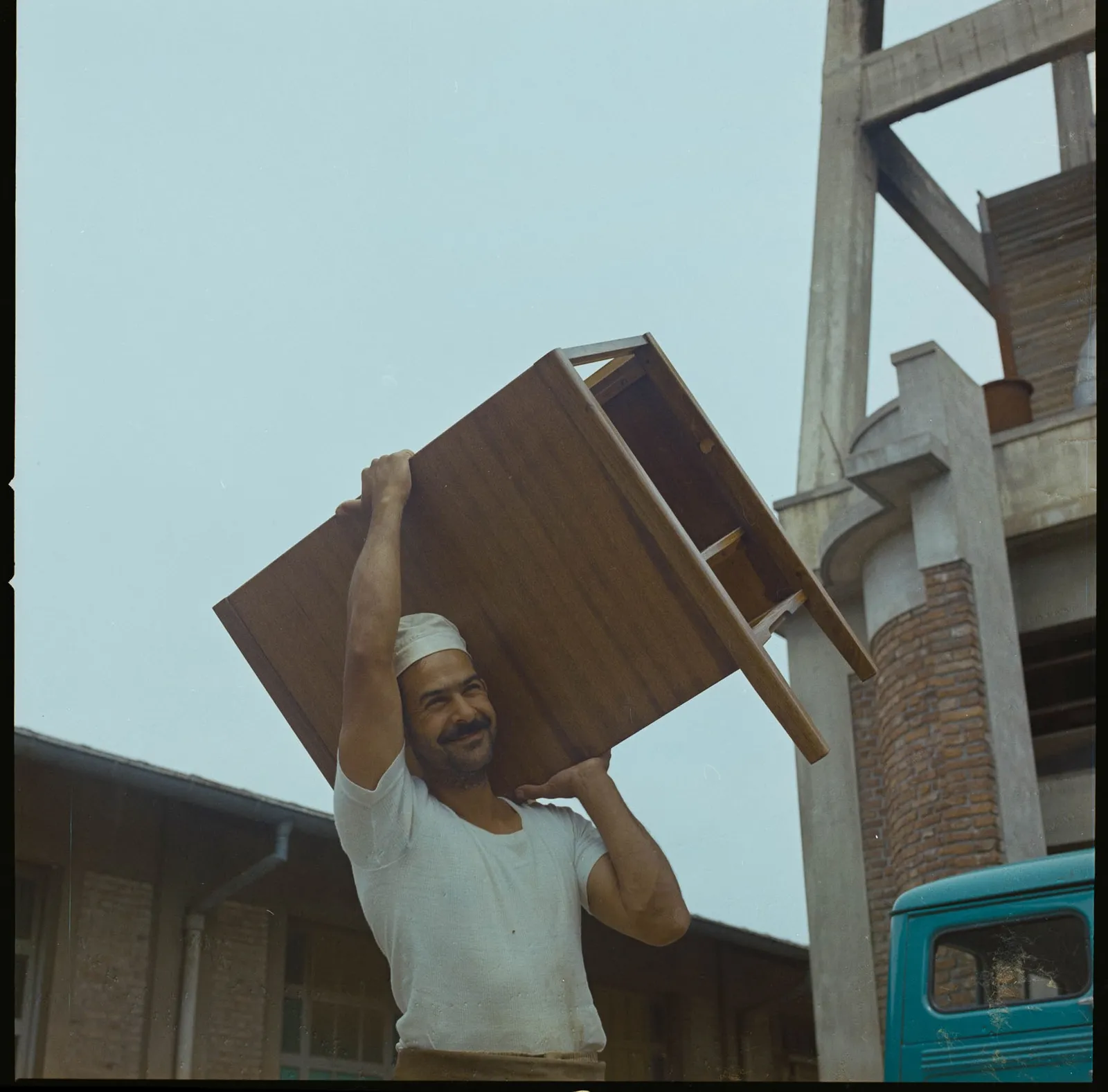 Hombre cargando un mueble de madera, 1964